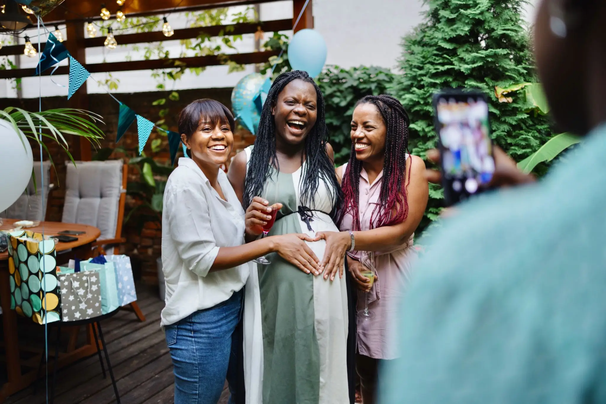 Pregnant woman smiling with friends at baby shower