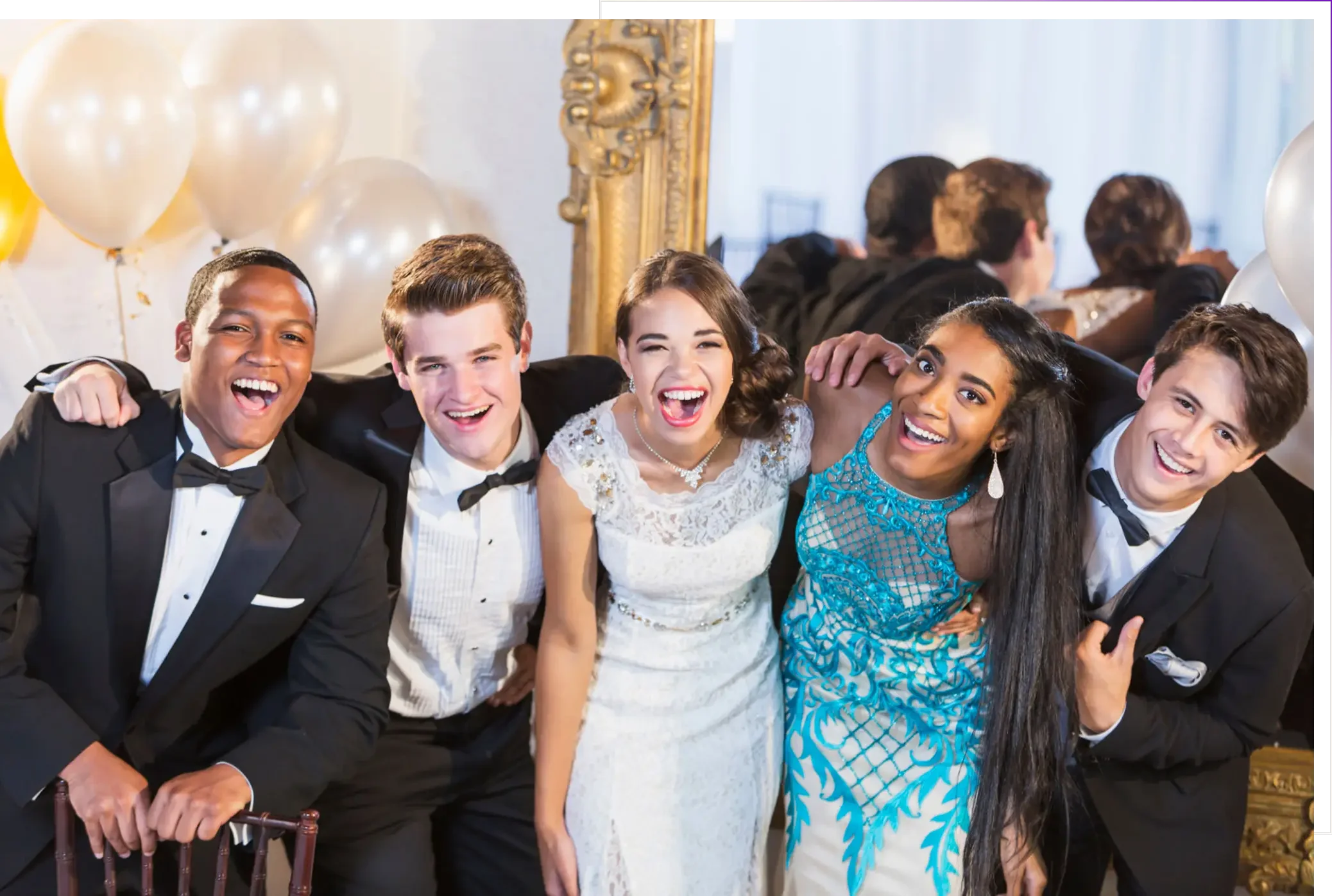 Five teens in formal wear smiling at camera
