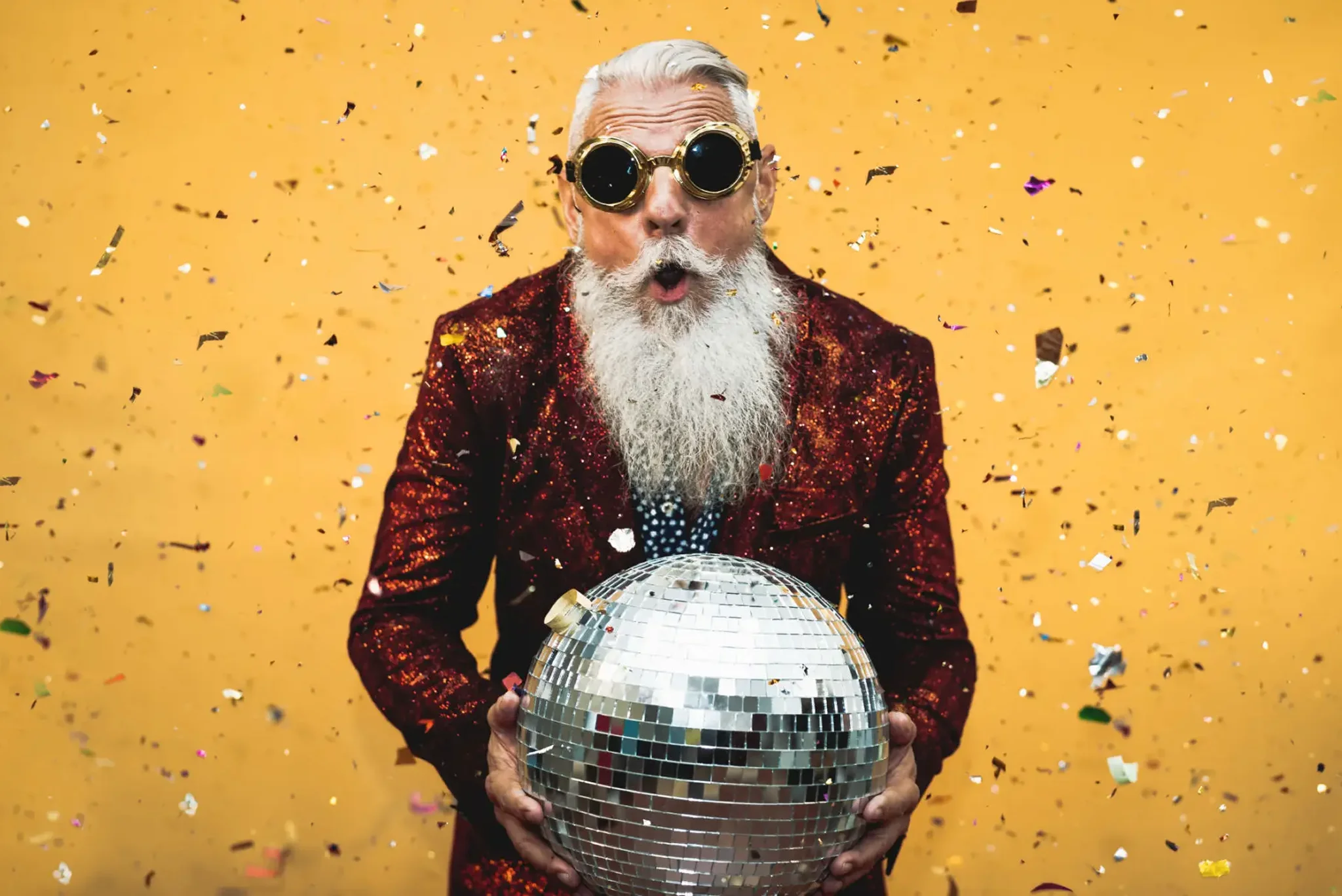 Bearded man wearing goggles holding disco ball
